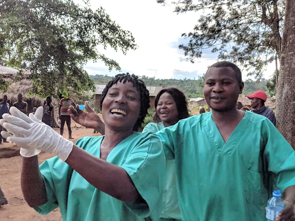 Health staff cheering one of the first cured patients coming out of the treatment centre