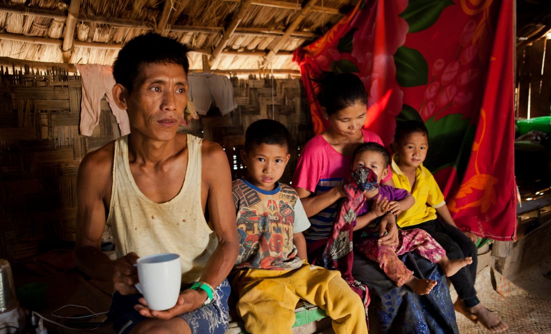 Thongsei Lupho Thongsei Lupho (44) and his wife Mary and some of their seven children. His son sitting next to him is also HIV-positive and receives treatment from the MSF clinic in Moreh. Thongsei is HIV positive and has been a patient at the MSF Clinic in Moreh since 2012.
Thongsei used to work in charcoal and cultivation. Since he contracted HIV, his health has deteriorated and he is no longer able to do manual labour. He has seven children; the oldest is 17 years old and the youngest one 14 months old. Mary takes care of the children. Thongsei contracted HIV through drug use: Lupho had used drugs in the past to gain social acceptance in an area where tribal tensions had fostered a lack of trust amongst people.
He first visited the MSF clinic because he thought he had TB. By that point, he had stopped taking drugs and married. He was in fact diagnosed HIV-positive. His failing strength meant he was no longer able to work. He was afraid of discrimination and isolated himself. He thought he could no longer mingle with other people in public spaces. His eldest daughter, Lamknohat, and several of his other children are also HIV-postive. Lamknohat feels ashamed and doesn’t want other people to know.
